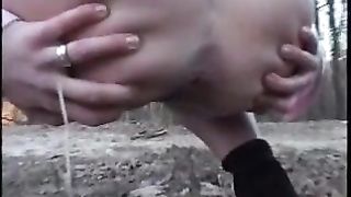 Woman pisses in the woods and uses tube to direct piss