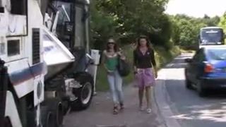 Two hot girls peeing near a white truck