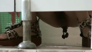 Shaved girl shitting over toilet