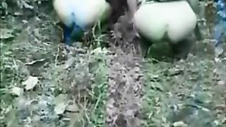 Two girls poop together in nature