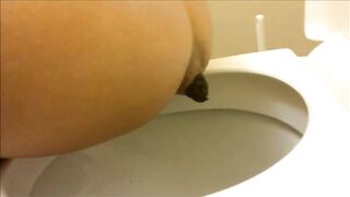 Sweet brunette girl pooping in toilet