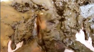 A girl in jeans plays in a bowl of shit