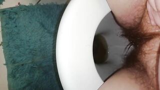 Woman shits in the toilet, closeup of her ass