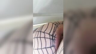 Man sticks his tongue out while wearing a fishnet bodysuit