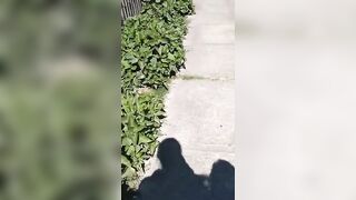 Slut pisses all over a sidewalk in broad daylight
