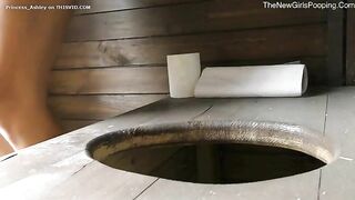 Pretty gal pooping in the wooden toilet