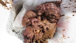 Woman is squatting over toilet and taking a huge shit