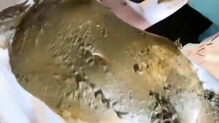 Girl lies in a pile of shit and plays with it