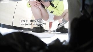 Girl in yellow bends over to smell and inspect a pile of shit