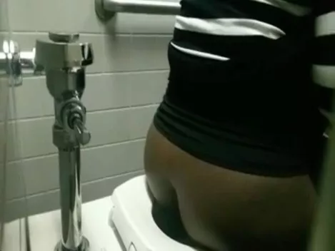 Fat ebony peeing in a public bathroom