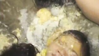 Two women drink each other's piss in a bathtub