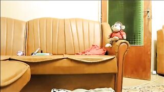 Woman squats and pisses on the floor next to monkey toy