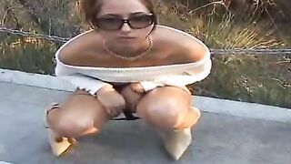 Woman shits in a blue plastic container in public