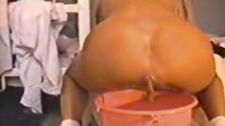 Blonde woman takes a shit into a bucket while wearing lingerie