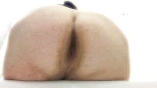 A girl takes a huge shit while bent over in a bathtub