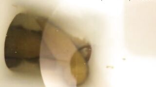 Girl standing over a toilet trying to take a shit