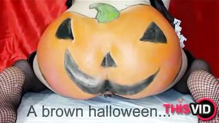 Woman in fishnets and pumpkin costume plays with her shit