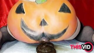 Woman in fishnets and pumpkin costume plays with her shit