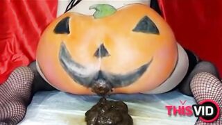 Woman in fishnets and pumpkin costume plays with her shit