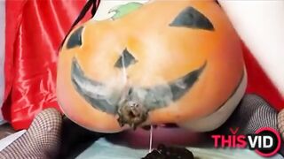 Woman in fishnets and pumpkin costume plays with her shit