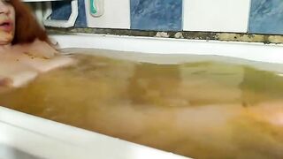 Woman plays in her own shit in a bathtub