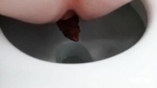 Woman takes a shit while squatting on the toilet