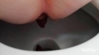Woman takes a shit while squatting on the toilet