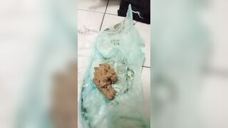 Woman holds a bag of her own shit