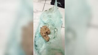 Woman holds a bag of her own shit
