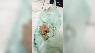 Woman holds a bag of her own shit