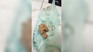 Woman holds a bag of her own shit