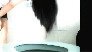 Woman takes a massive shit on the toilet in a blue bathroom
