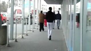 Woman squats in pants and shits on the sidewalk