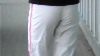 Woman squats in pants and shits on the sidewalk