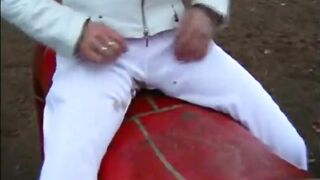 Girl in white dress takes a shit on a red dragon playground ride
