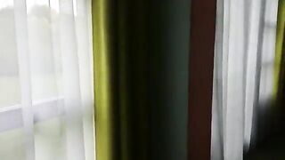 Man lays on his back in pink blanket while woman shits on his face