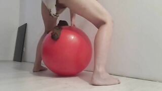 Woman pushes out a pile of shit on a ball while being filmed