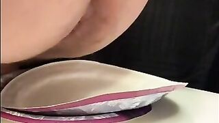 Girl stands over plate and shits on it