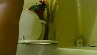 Girl takes a shit on the toilet with her pants around her ankles