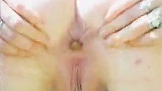 Spreading her cheeks to poop outdoor on a field