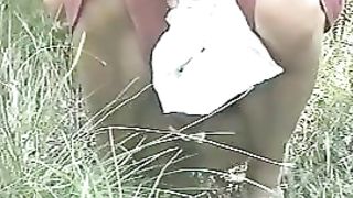 Hairy girl shitting on the grass outdoor