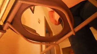 Fat woman sitting half naked on a homemade toilet