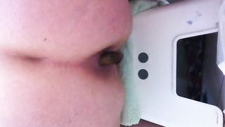 Mature chubby woman pooping on a white toilet