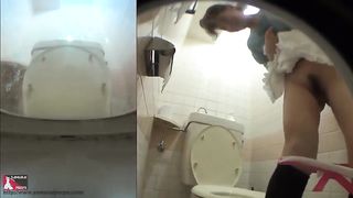 Sexy girl peeing in a public bathroom
