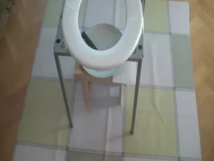 Sexy babe shitting on a home made toilet