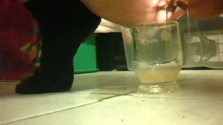 Girl peeing in a glass