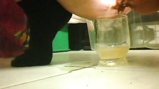 Girl peeing in a glass