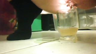 Girl peeing in a glass