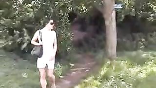 Brunette in white dress peeing outdoor
