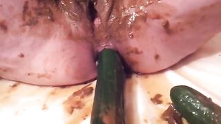 Cucumber in her ass while she smears poop
